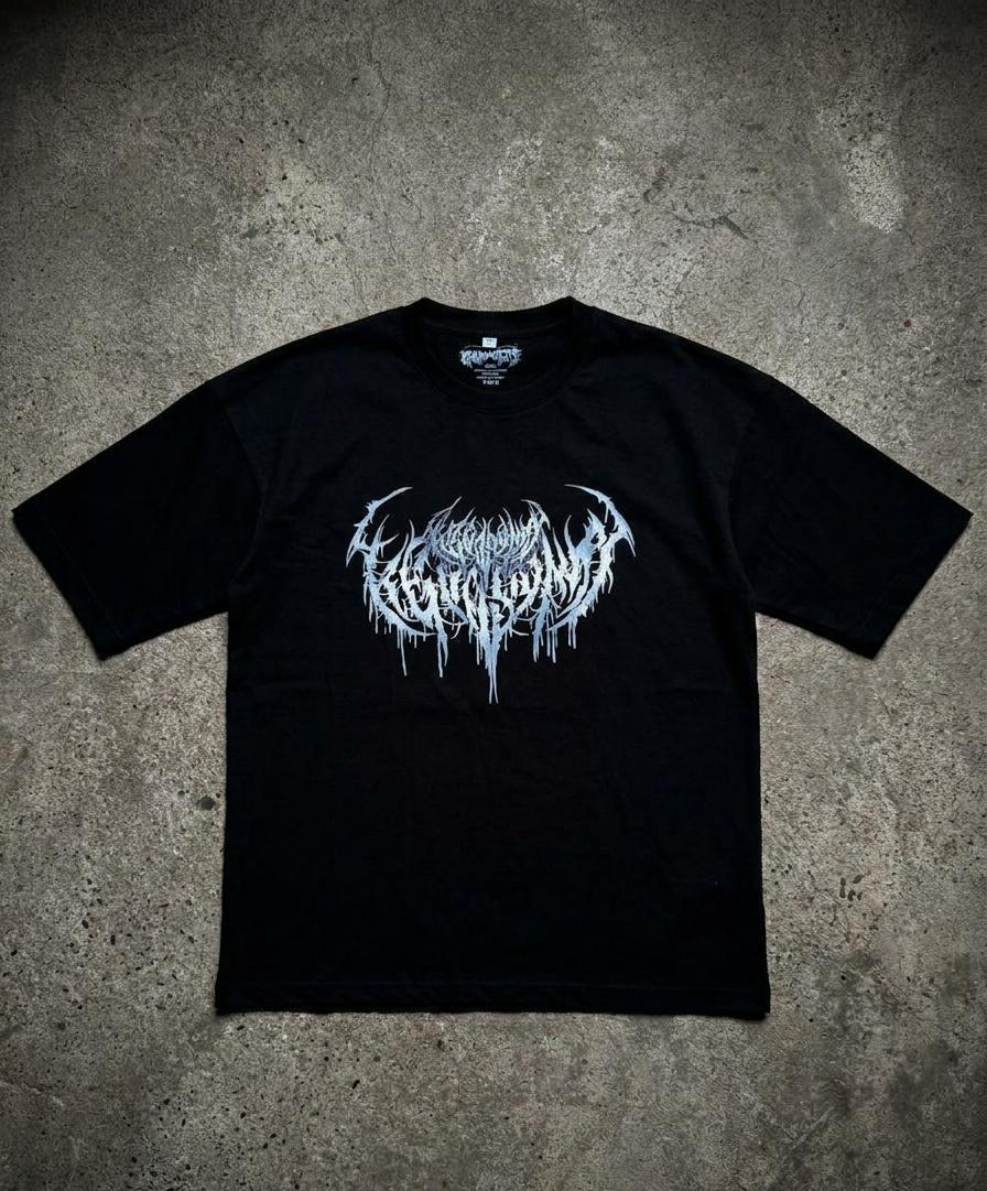 A black short-sleeve t-shirt with a white and silver metallic-style graphic logo on the chest, laid flat on a textured gray concrete background. A Higgsfield brand label is visible inside the collar, and a Higgsfield AI watermark is in the bottom right corner.